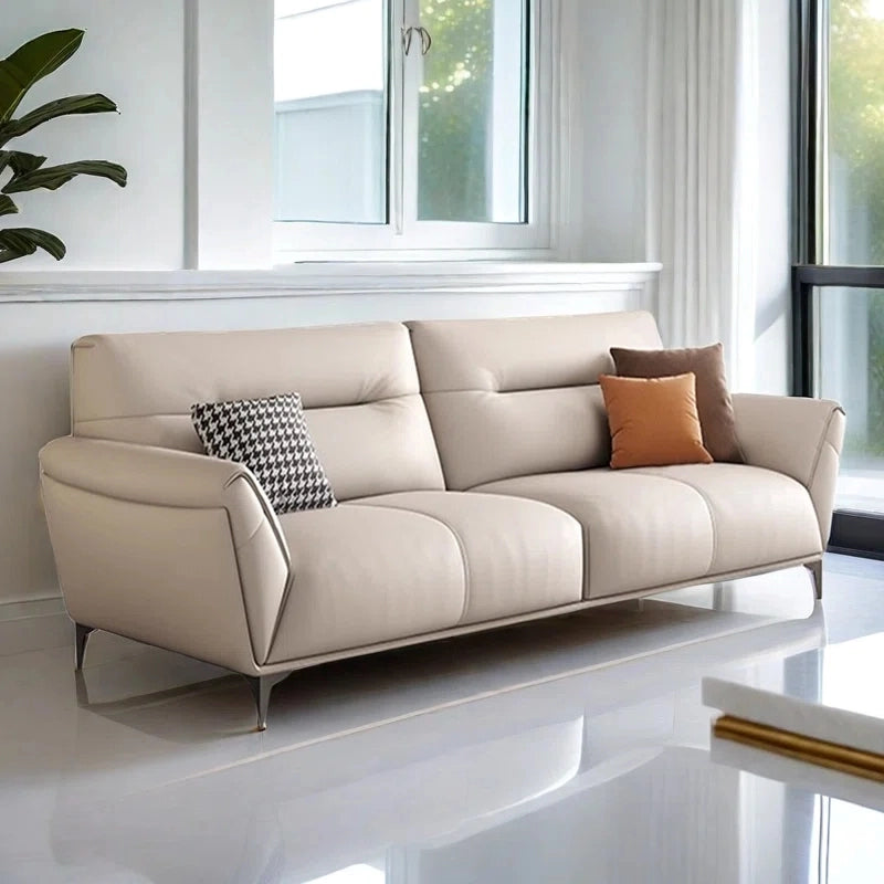 The silhouette features a straight-line base with flared armrests, soft yet structured seat cushions, and a segmented backrest for full support.